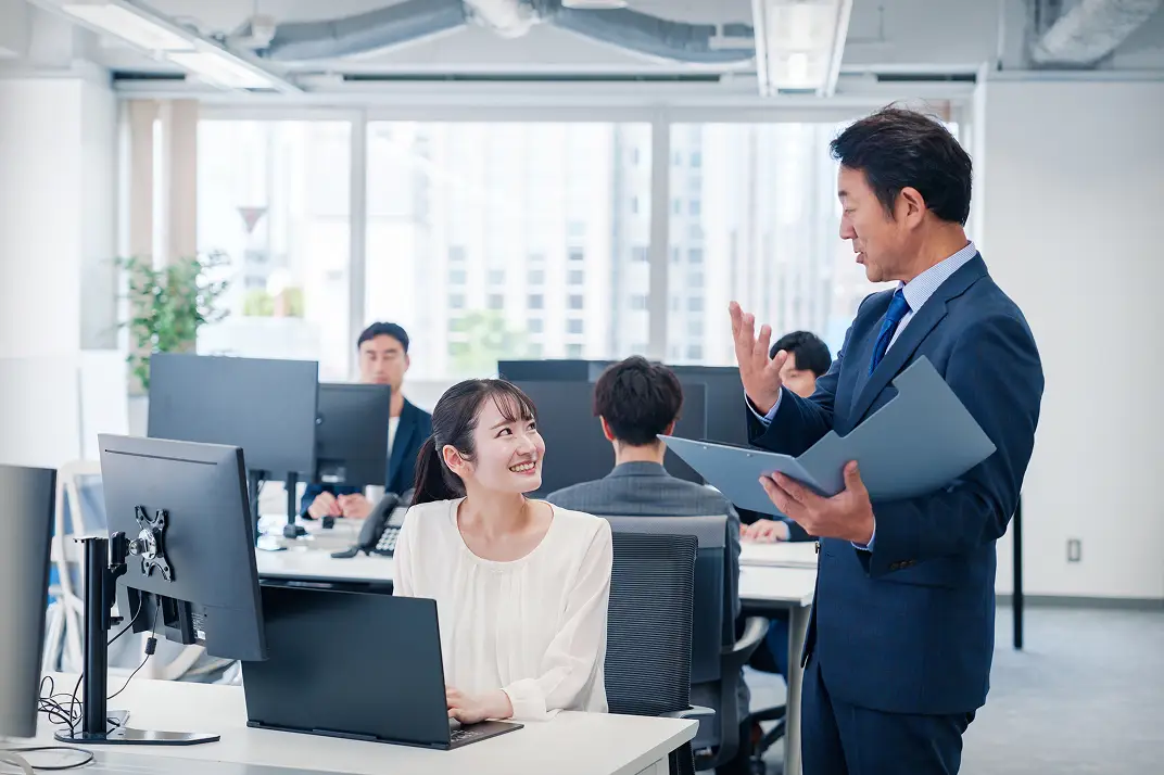 職場でコミュニケーションをとるビジネスパーソン